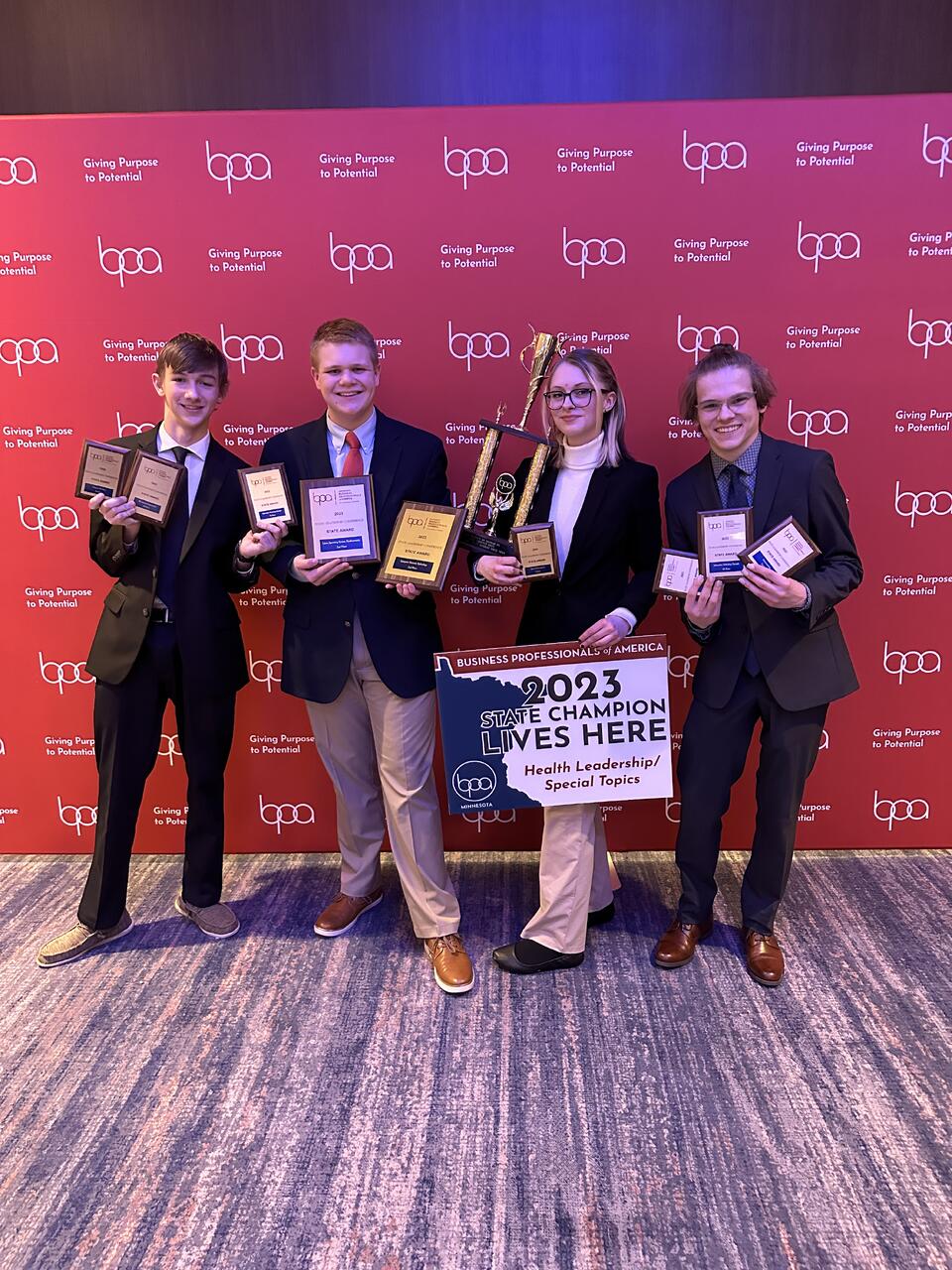 Caleb J. Carlson posing with state-level technology competition award